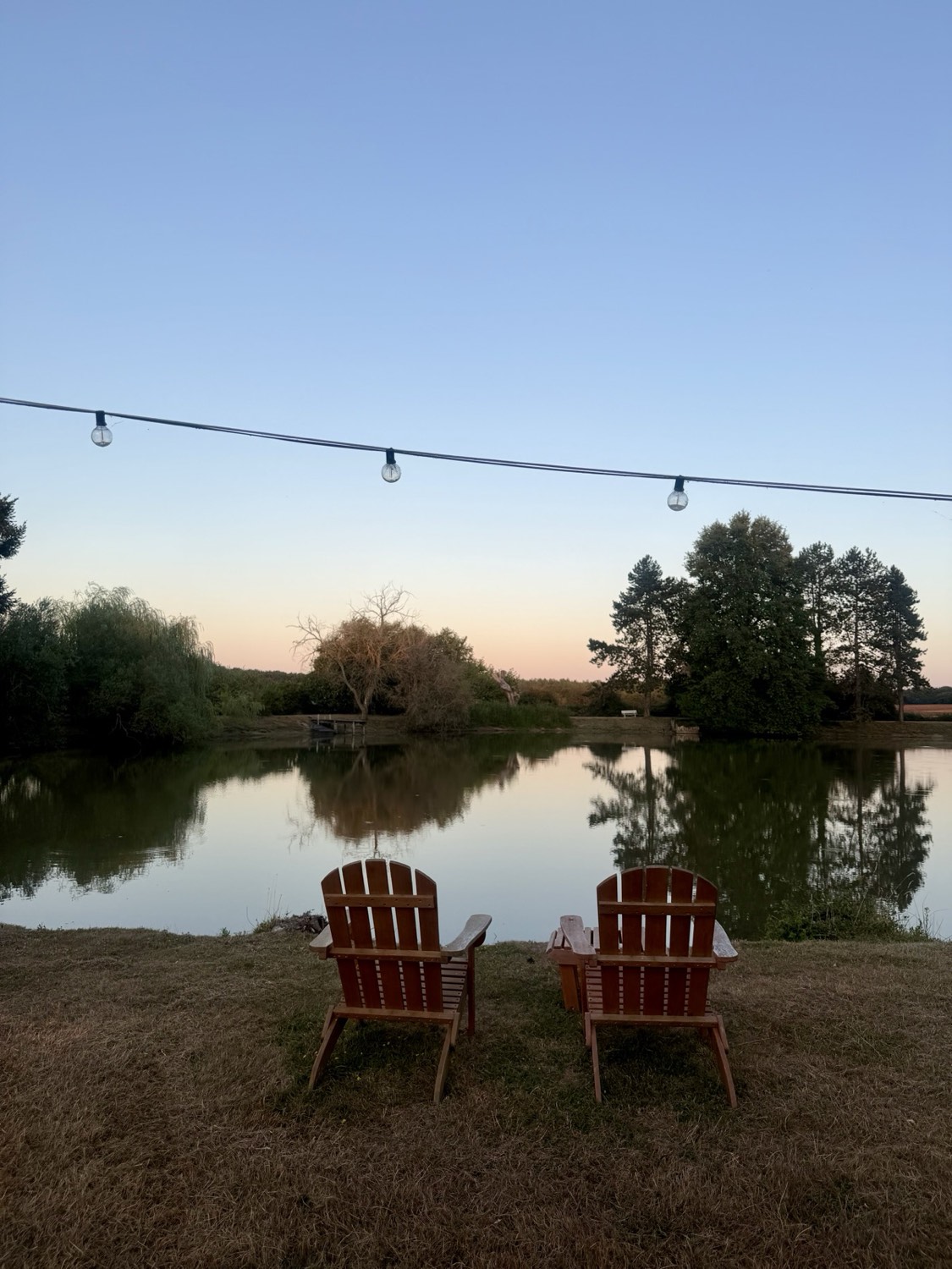 Deux fauteuils au bord de l'étang privé, au coucher du soleil