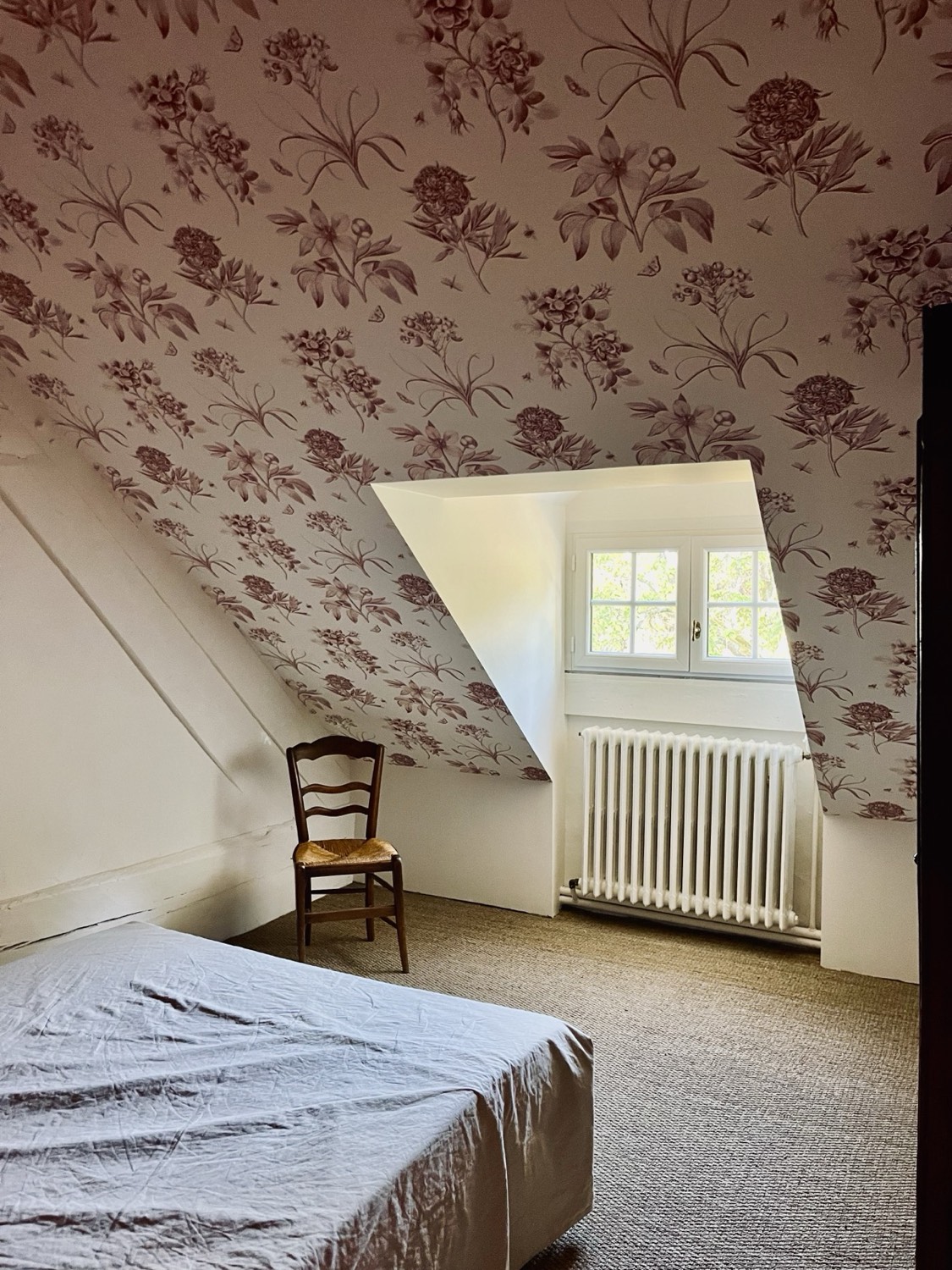 Chambre au papier peint fleuri, sous les combles
