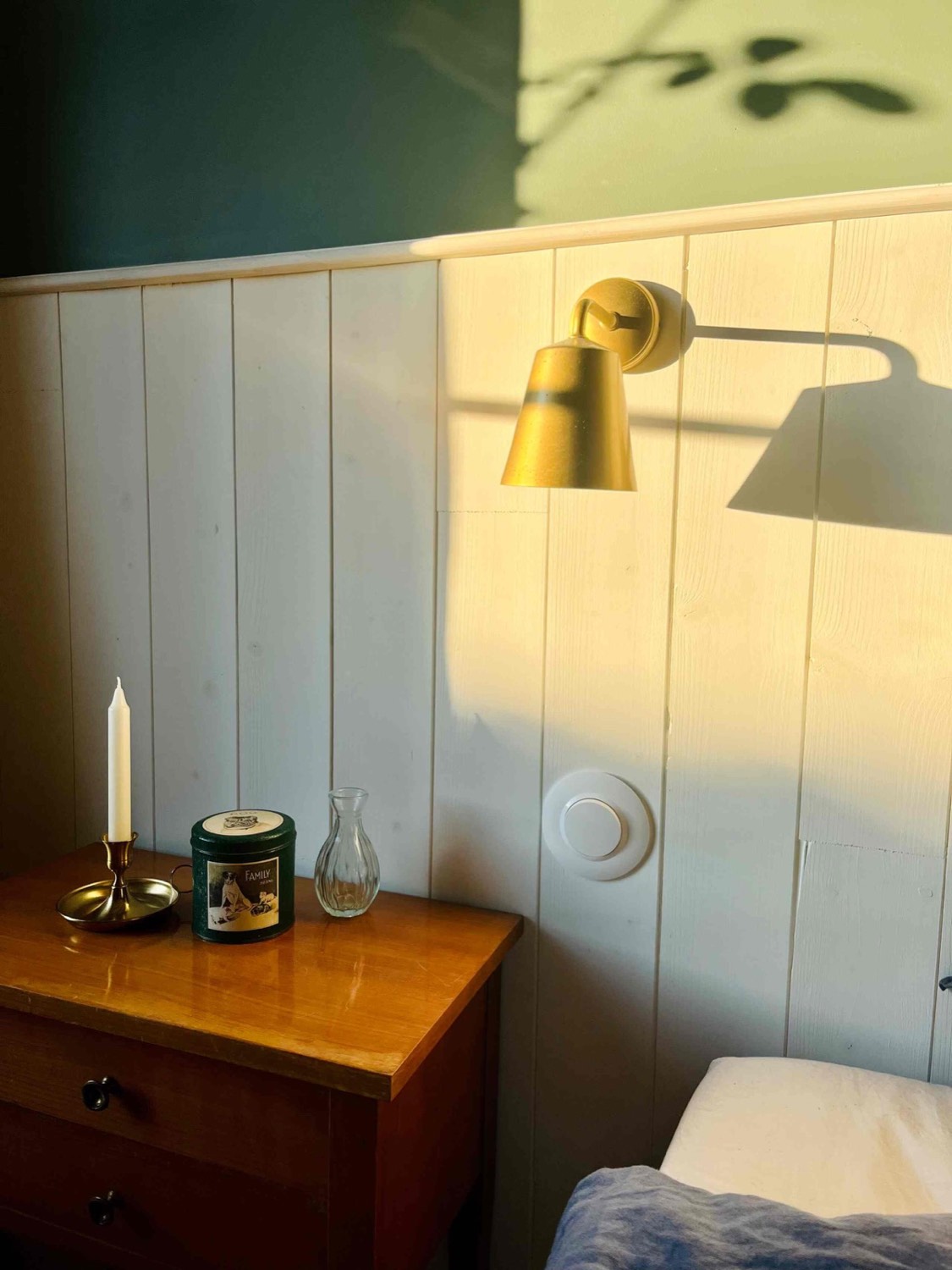 Chambre lumineuse aux appliques dorées et lambris blanc